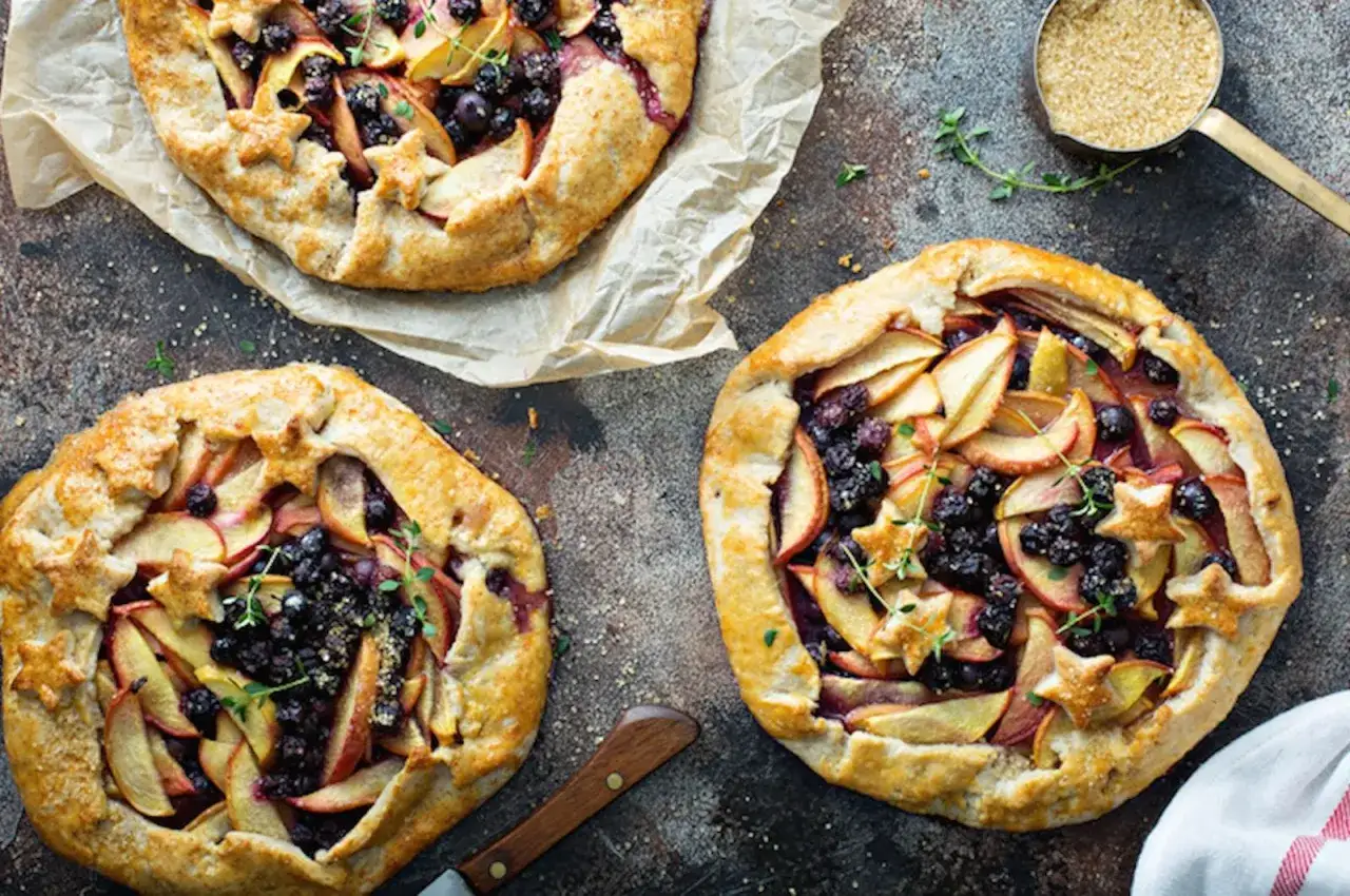 Tre galette rustiche con mele e frutti di bosco, perfette per una ricetta gallette dolci fatta in casa.