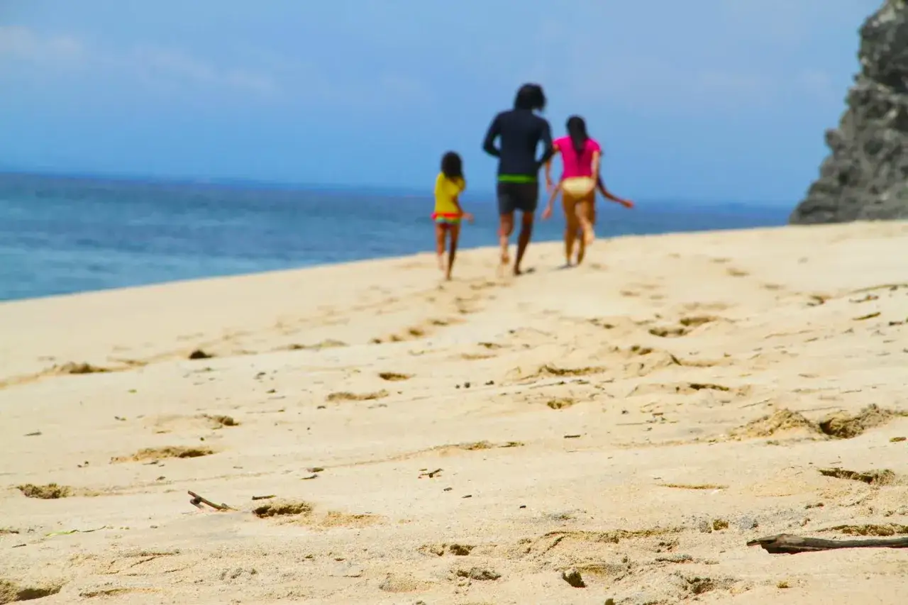 Rodzina biegnie po plaży, idealny czas, kiedy jechać na Bali.