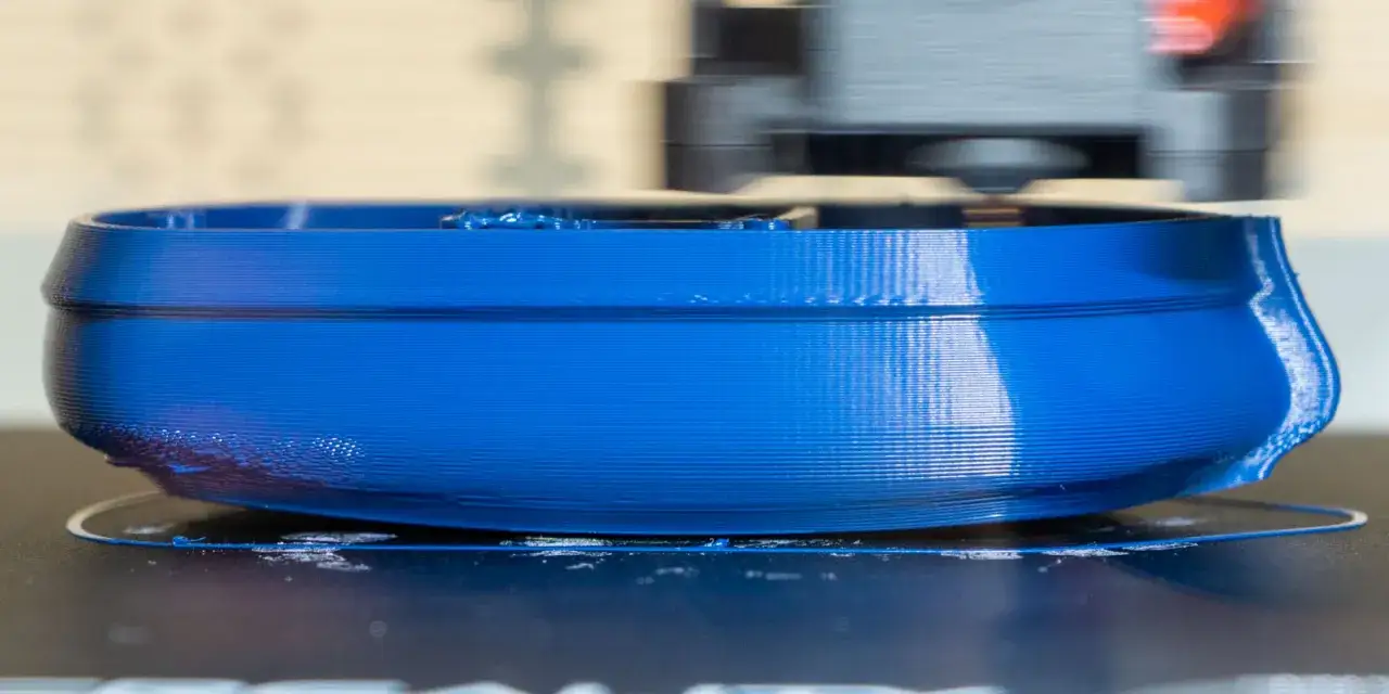 Niebieski wydruk 3D z ABS, widoczna głowica drukująca. Optymalna temperatura ABS kluczowa dla jakości.