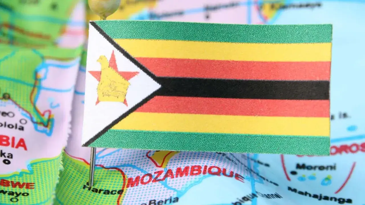 Flaga Zimbabwe na mapie, symbolizująca trudności gospodarcze i inflację.