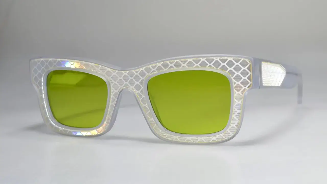 Moderne Sonnenbrille mit auff&auml;lligem Gittermuster und leuchtend gr&uuml;nen Gl&auml;sern. Perfekt f&uuml;r einen stylischen Face ID-Moment.