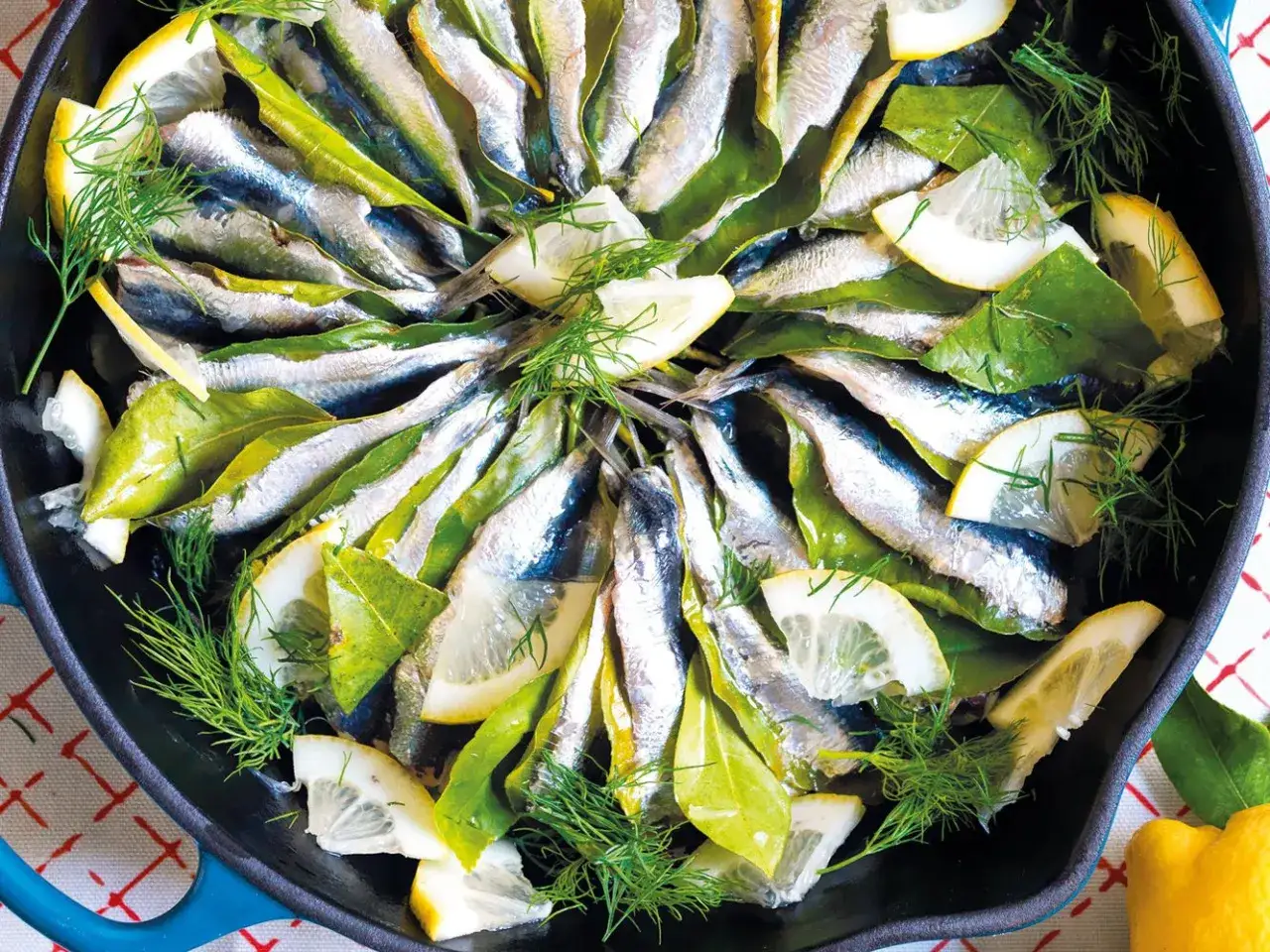 Sardine in padella con limone, alloro e finocchietto, pronte per essere gustate.