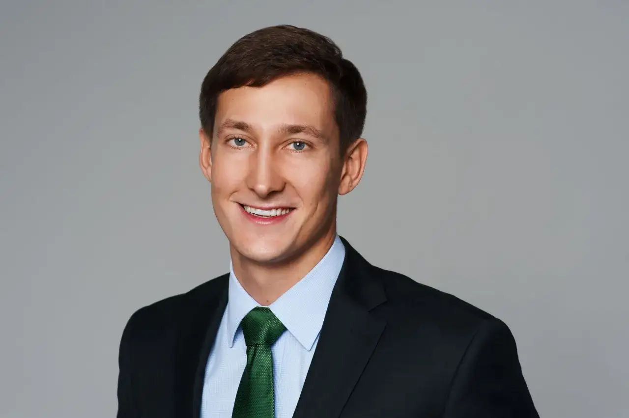 Uśmiechnięty mężczyzna w garniturze i zielonym krawacie. To jego zdjecie profilowe.