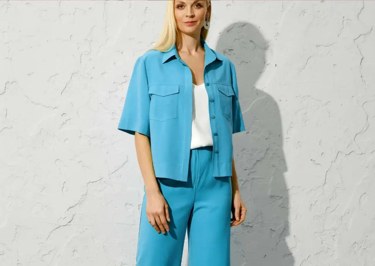 Une femme porte un ensemble bleu turquoise. Quelle couleur va avec le bleu turquoise vêtement ? Le blanc est une option parfaite.