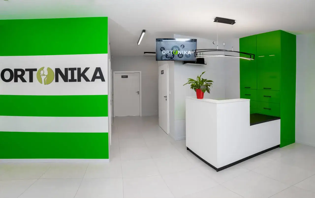 Recepcja kliniki ORTONIKA z zielonymi akcentami i logo.