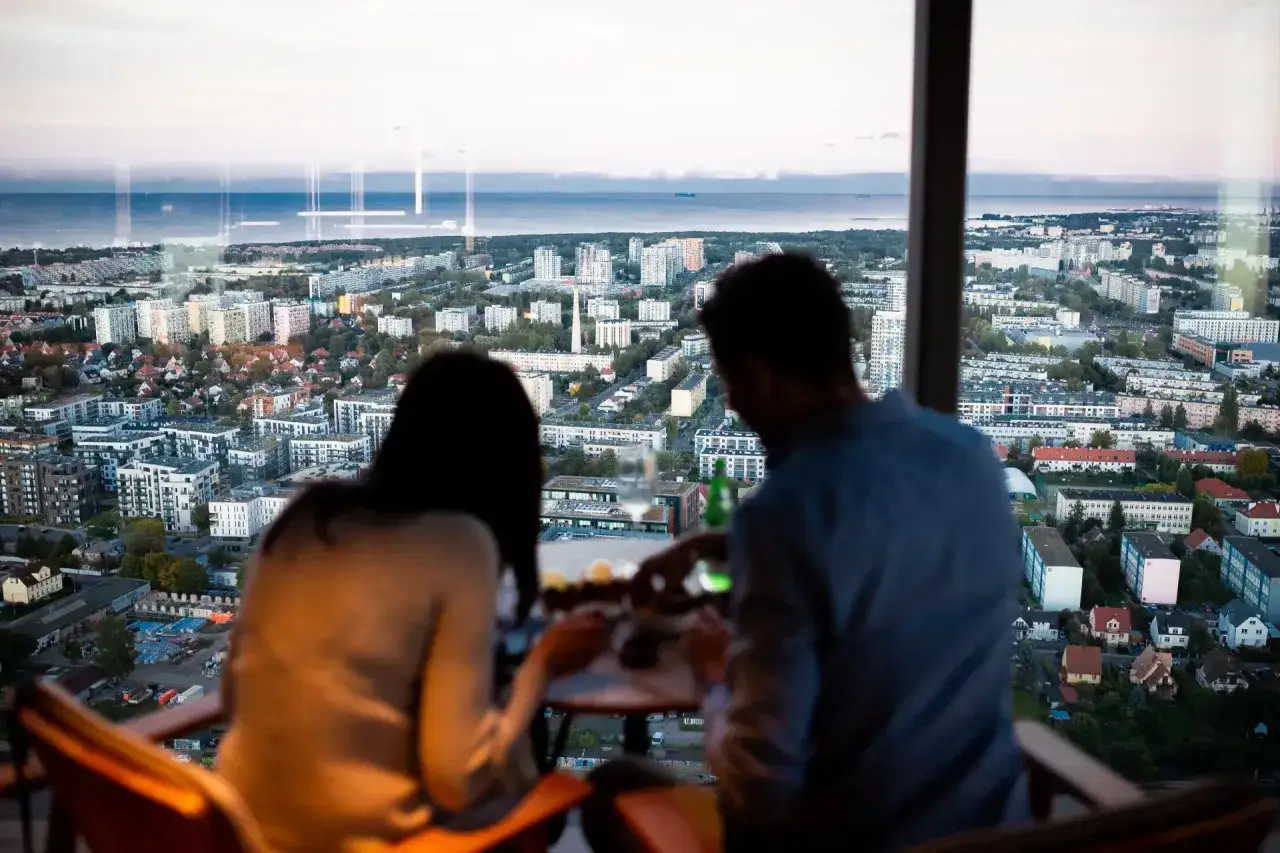 Para delektuje się widokiem na Gdynię z restauracji na dachu. Romantyczne Gdynia atrakcje dla par.