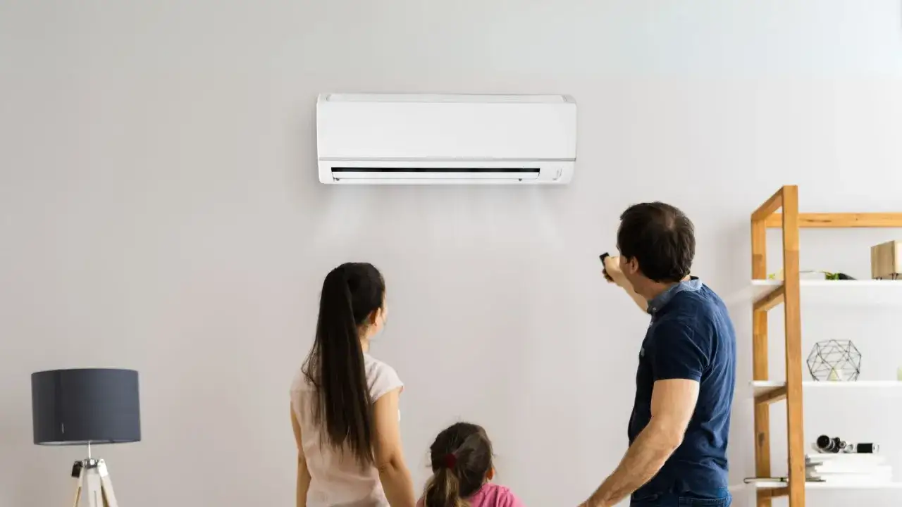 Rodzina patrzy na działającą klimatyzację na ścianie.