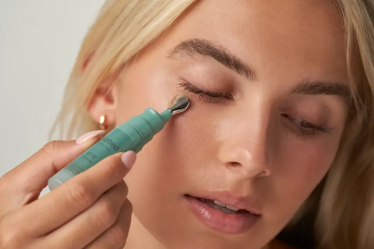 Donna applica siero contorno occhi con applicatore metallico. Scopri come applicare il siero contorno occhi per un look radioso.