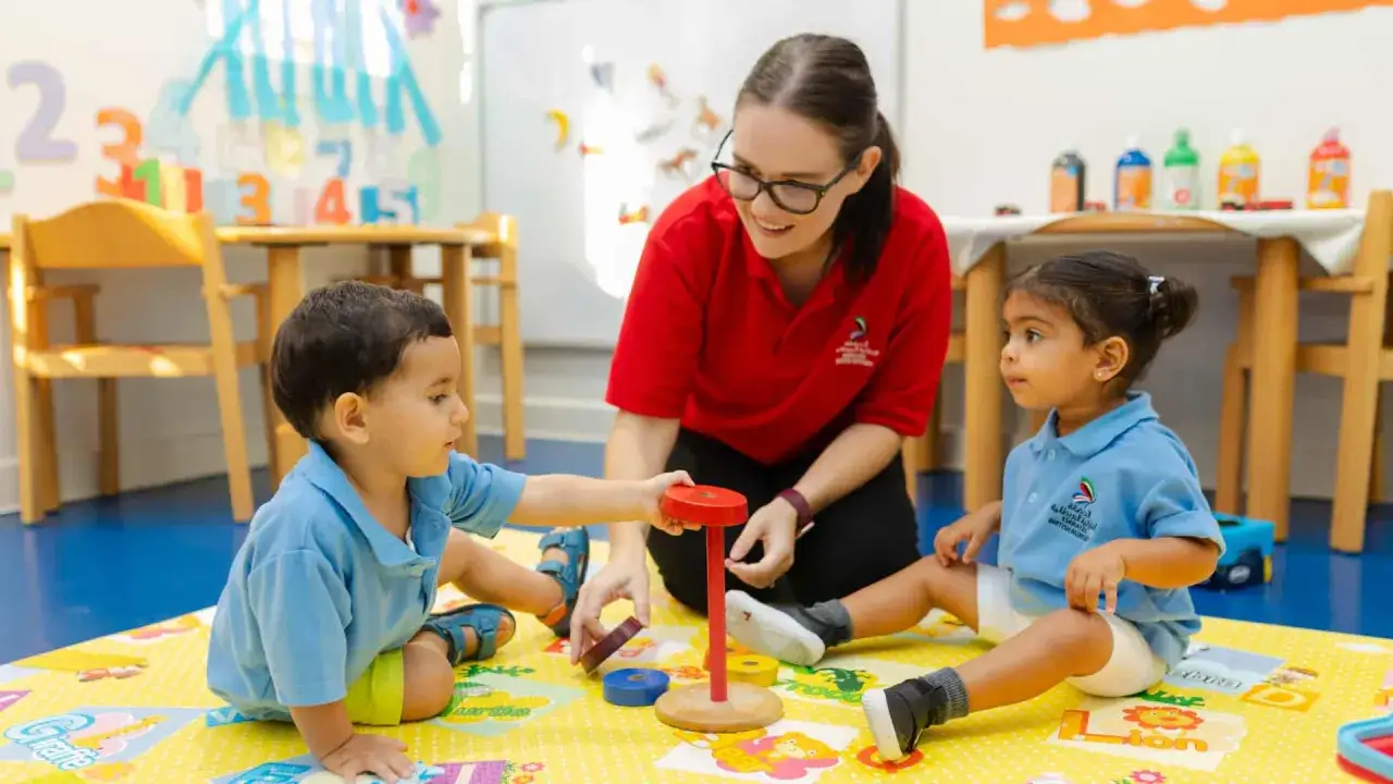Lehrerin erklärt Kindern die Regeln der gewaltfreien Kommunikation beim Spielen.