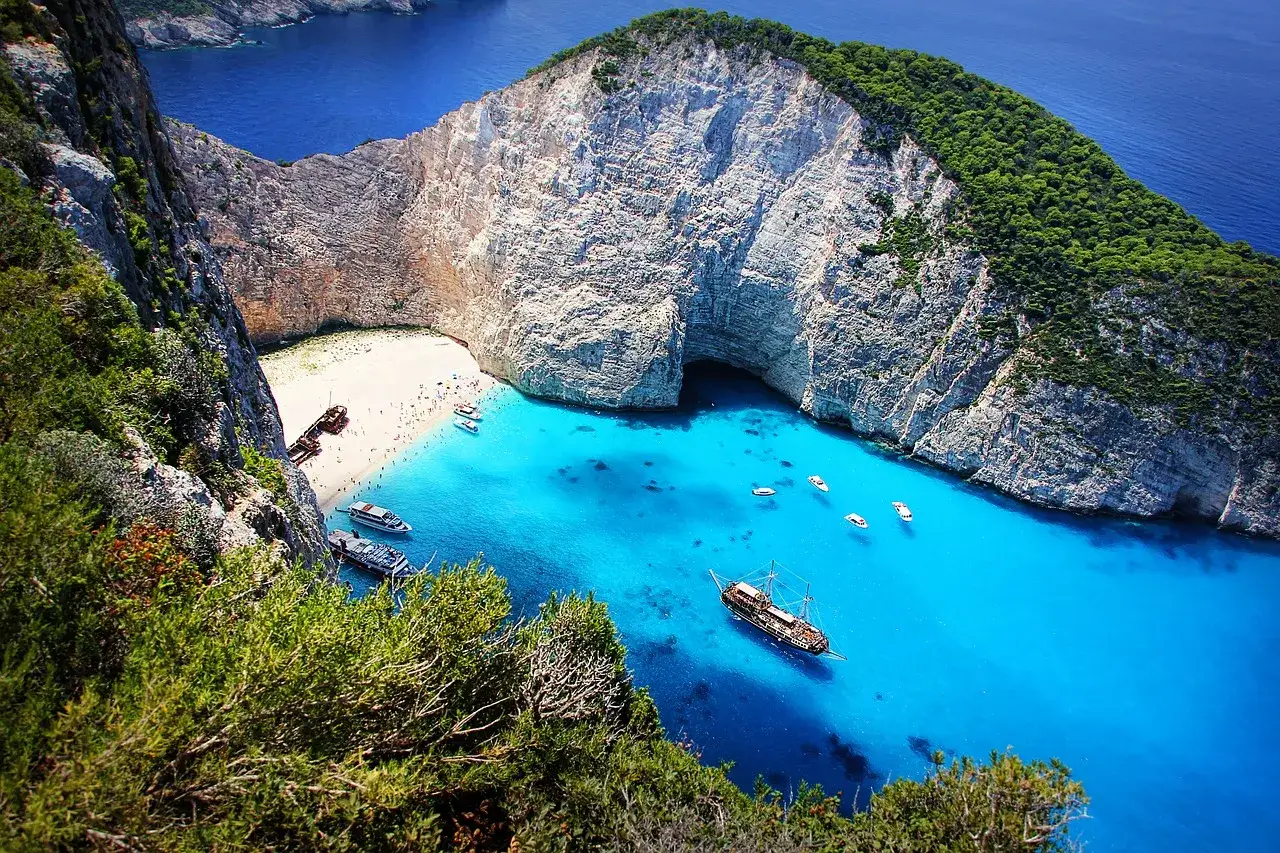 Traumhafter griechenland strand mit t&uuml;rkisfarbenem Wasser, wei&szlig;en Klippen und Schiffen. Ein verstecktes Paradies.