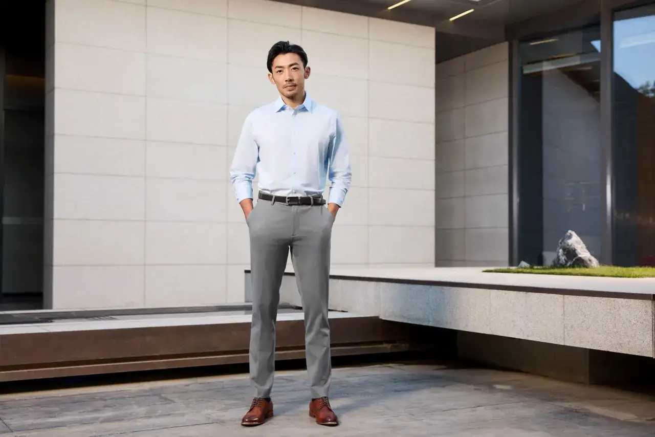 Ein Mann im hellblauen Hemd und grauer Hose, ein stilvolles Outfit, das Herren gut steht.