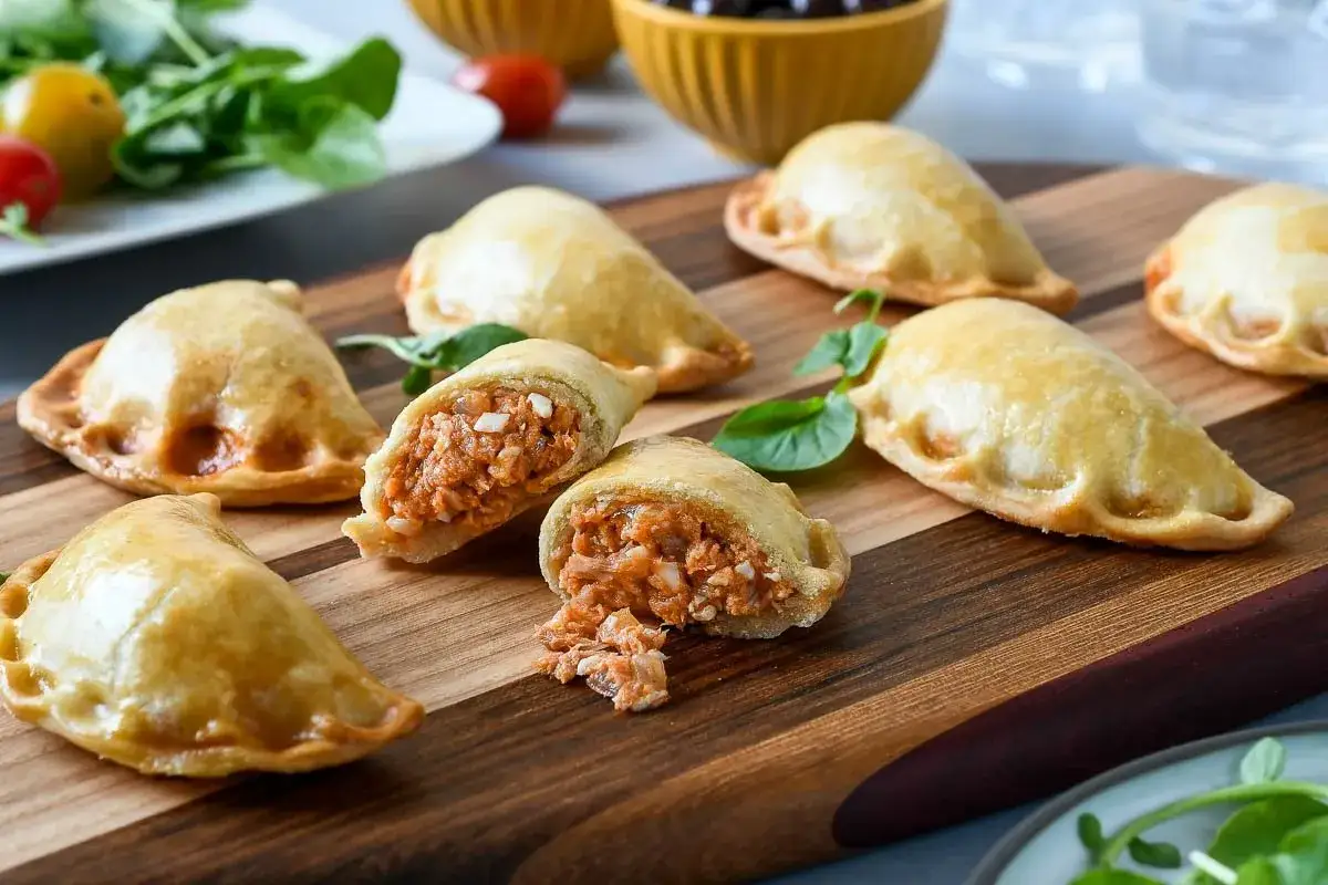 Deliciosas empanadillas al horno, doradas y crujientes, rellenas de un sabroso guiso. Perfectas para compartir.