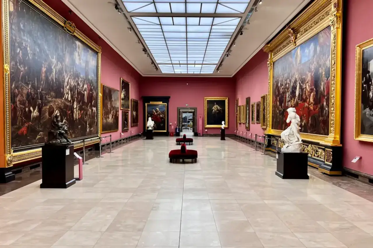 Wnętrze galerii sztuki w Krakowie, z wielkimi obrazami i rzeźbami. Wspaniałe muzea w Krakowie zapraszają do podziwiania historii.