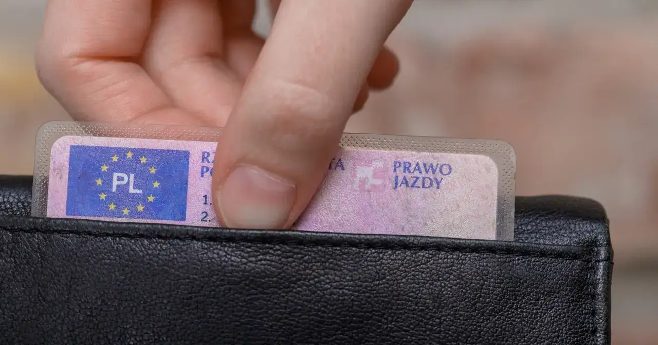 Dłoń wkłada prawo jazdy do portfela. Po 3 latach oczekiwania na powrót dokumentu, czas na badania lekarskie.
