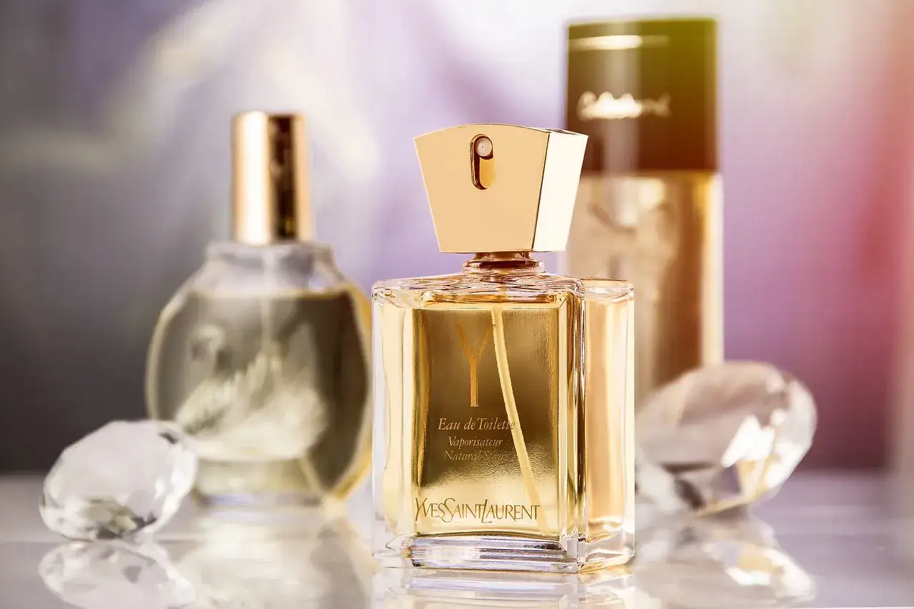 Złota butelka perfum Yves Saint Laurent z napisem 