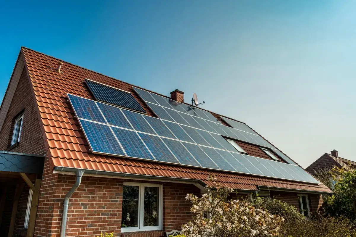 Dom z panelami fotowoltaicznymi (PV) na dachu. To rozwiązanie pozwala na produkcję własnej, czystej energii.