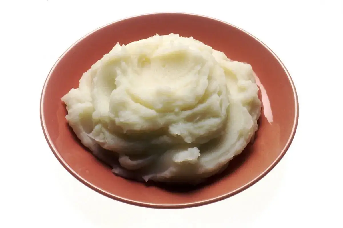 Puré de patatas cremoso en un plato rosado. Ideal para acompañar carnes, pescados o verduras. ¡Un clásico que nunca falla!
