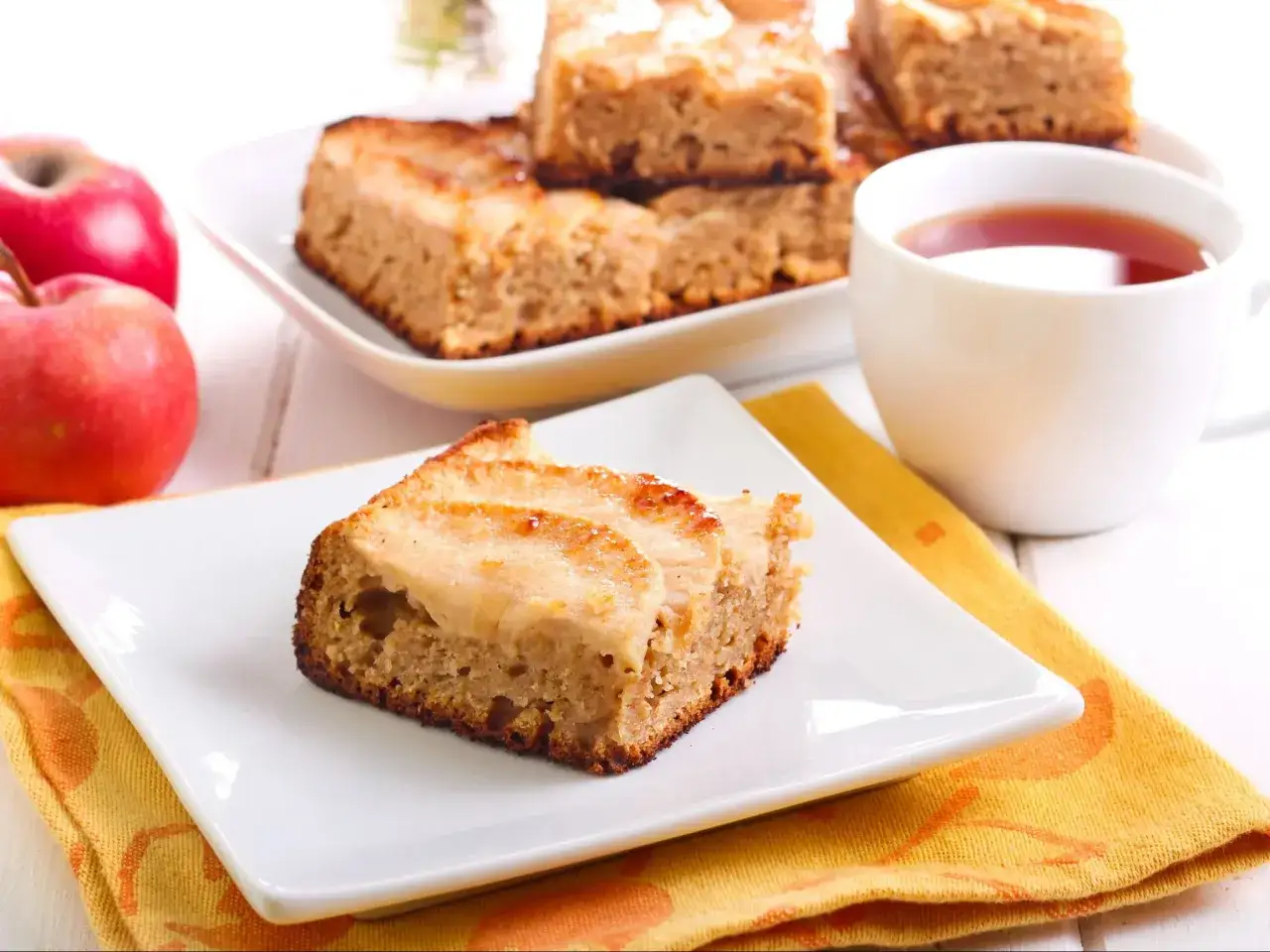 Pyszne ciasto z mąki pełnoziarnistej z jabłkami, podane z herbatą. Idealne na jesienne popołudnie.