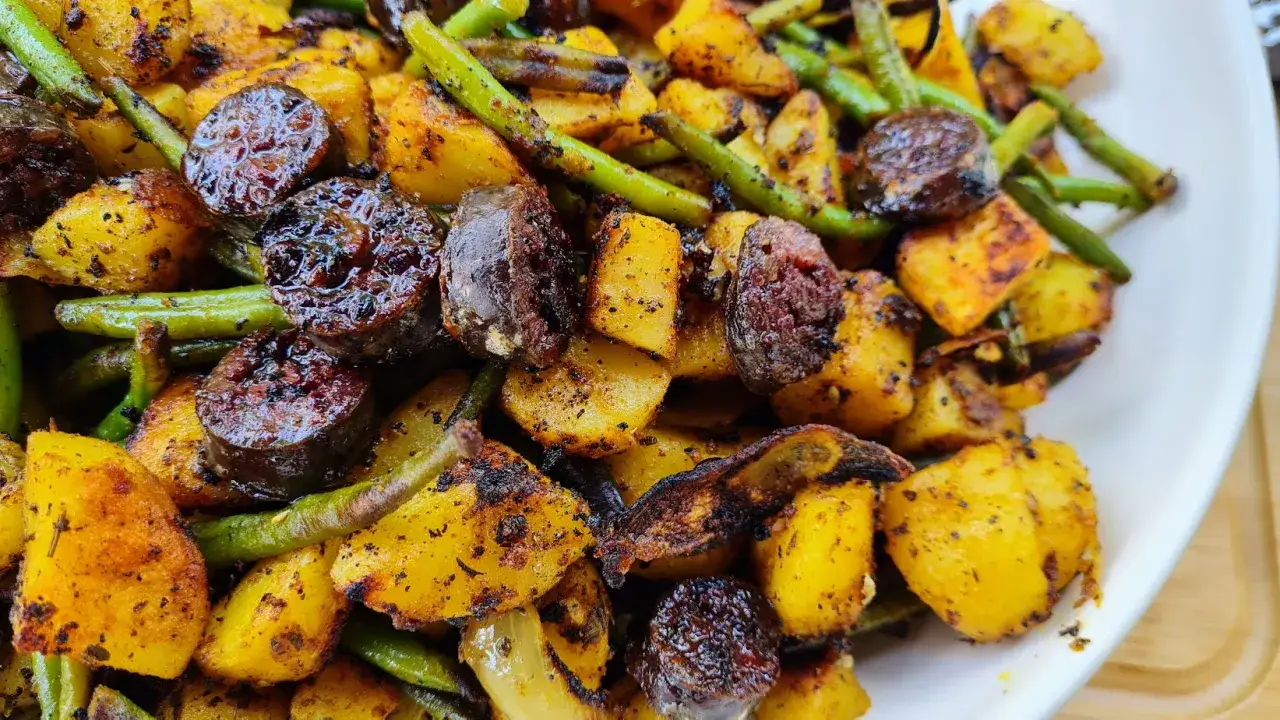 Plat savoureux de figatelli recette au four, avec pommes de terre rôties et haricots verts, le tout bien assaisonné.