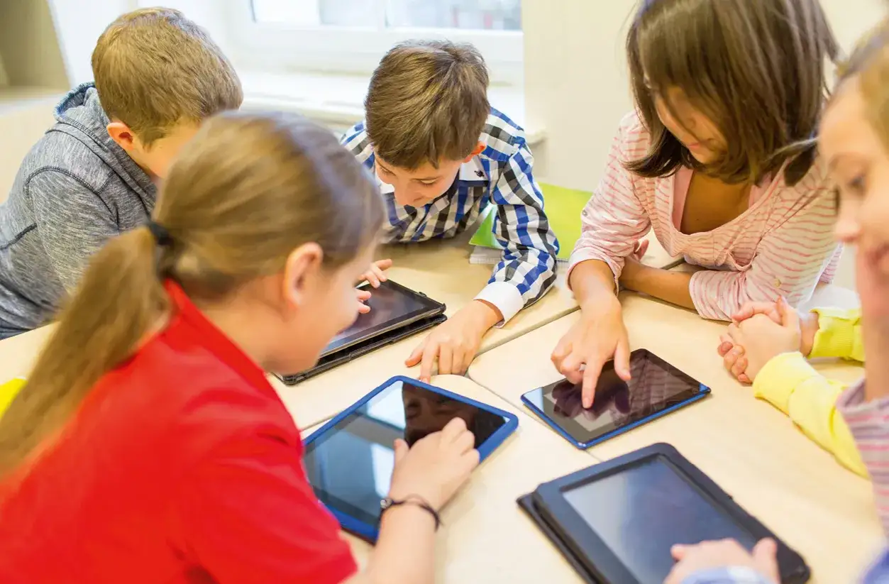 Kinder arbeiten konzentriert an Tablets, entwickeln gemeinsam neue projektideen schule.