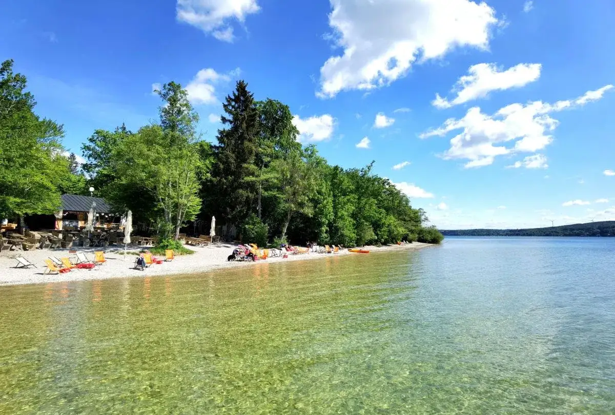 Sonnige Tage am Starnberger See: Ein ruhiger Strand mit Liegest&uuml;hlen und ein kleines Caf&eacute; laden zum Baden und Entspannen ein. Ein echter Geheimtipp!