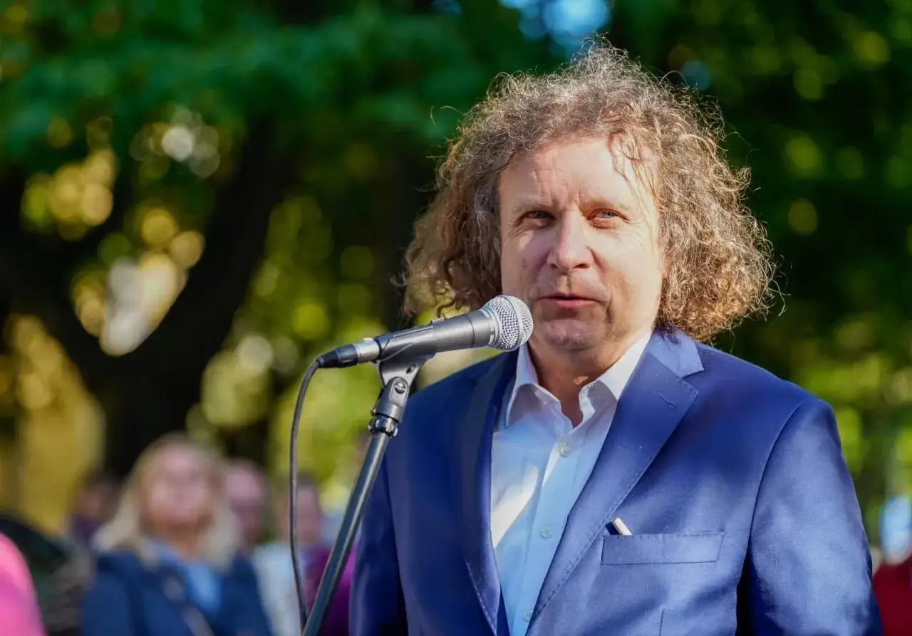 Prezydent Sopotu w niebieskiej marynarce przemawia do zgromadzonych ludzi.