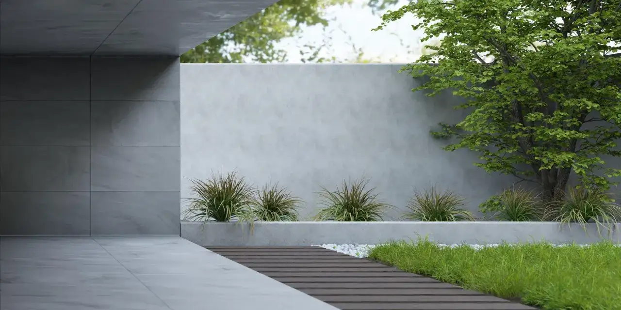 Nowoczesny ogród z betonowym płotem architektonicznym, ścieżką z desek i bujną zielenią.