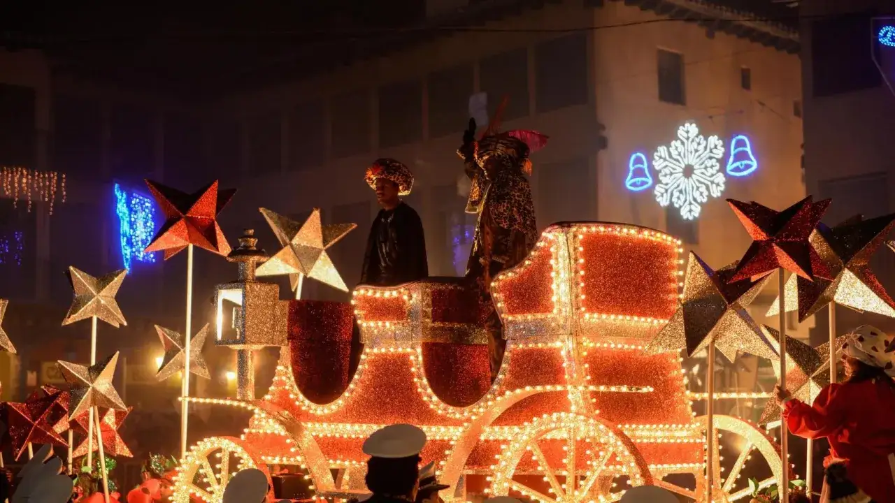 Carroza iluminada en la cabalgata Miralbueno, con figuras de Reyes Magos y estrellas decorativas.