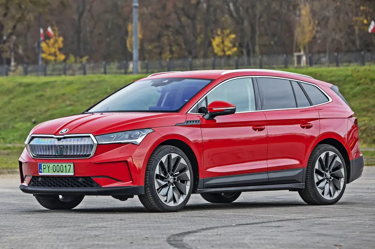 Czerwona Skoda Enyaq na zewnątrz, pokazująca jej imponujące skoda enyaq wymiary. Elegancki SUV z nowoczesnym designem.