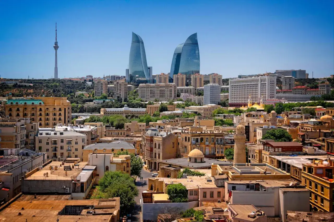 Baku, Azerbejdżan co zobaczyć: nowoczesne Flame Towers i wieża telewizyjna na tle zabytkowej zabudowy.