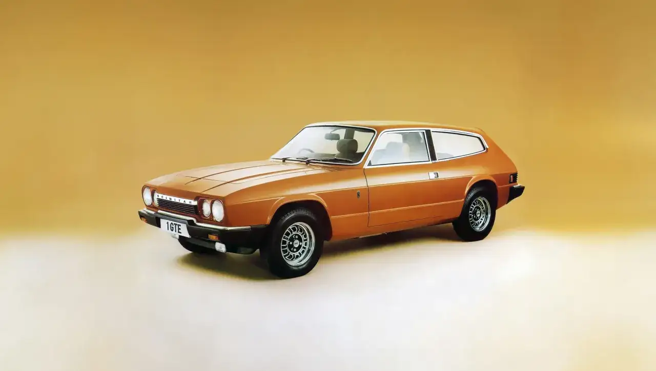 En orange Reliant Scimitar GT coupé står på en ljus bakgrund.