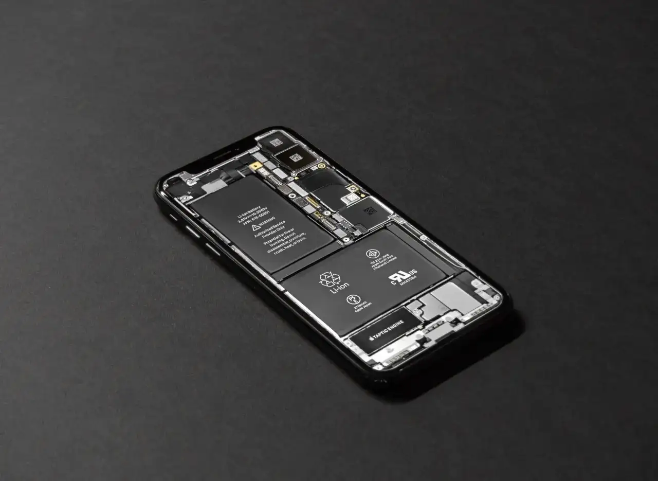 Rozłożony iPhone z widoczną baterią. Kalibracja baterii iPhone może być konieczna po wymianie.