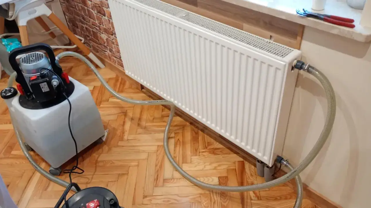 Płukanie instalacji grzewczej. Sprawdź cennik usług. Urządzenie do płukania podłączone do grzejnika.