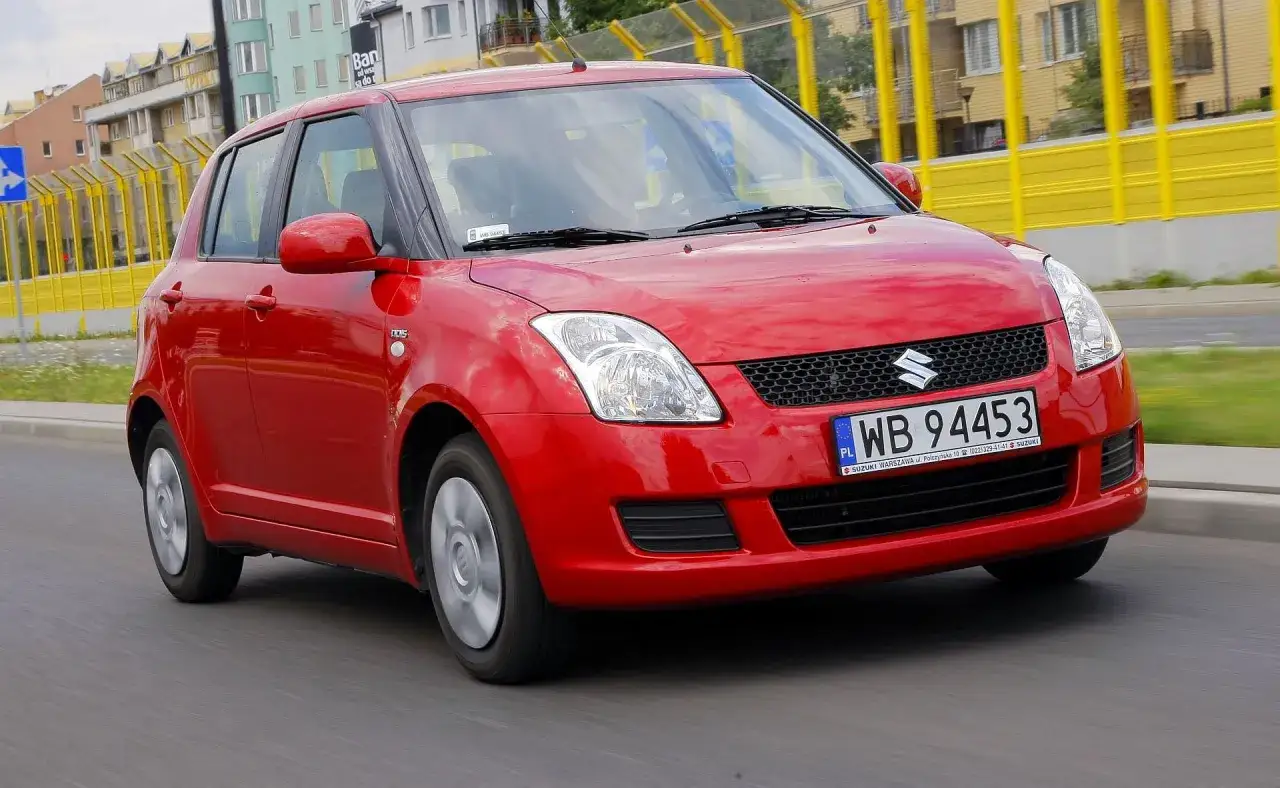 Czerwony Suzuki Swift 2008 na drodze, z widocznym numerem rejestracyjnym WB 94453.