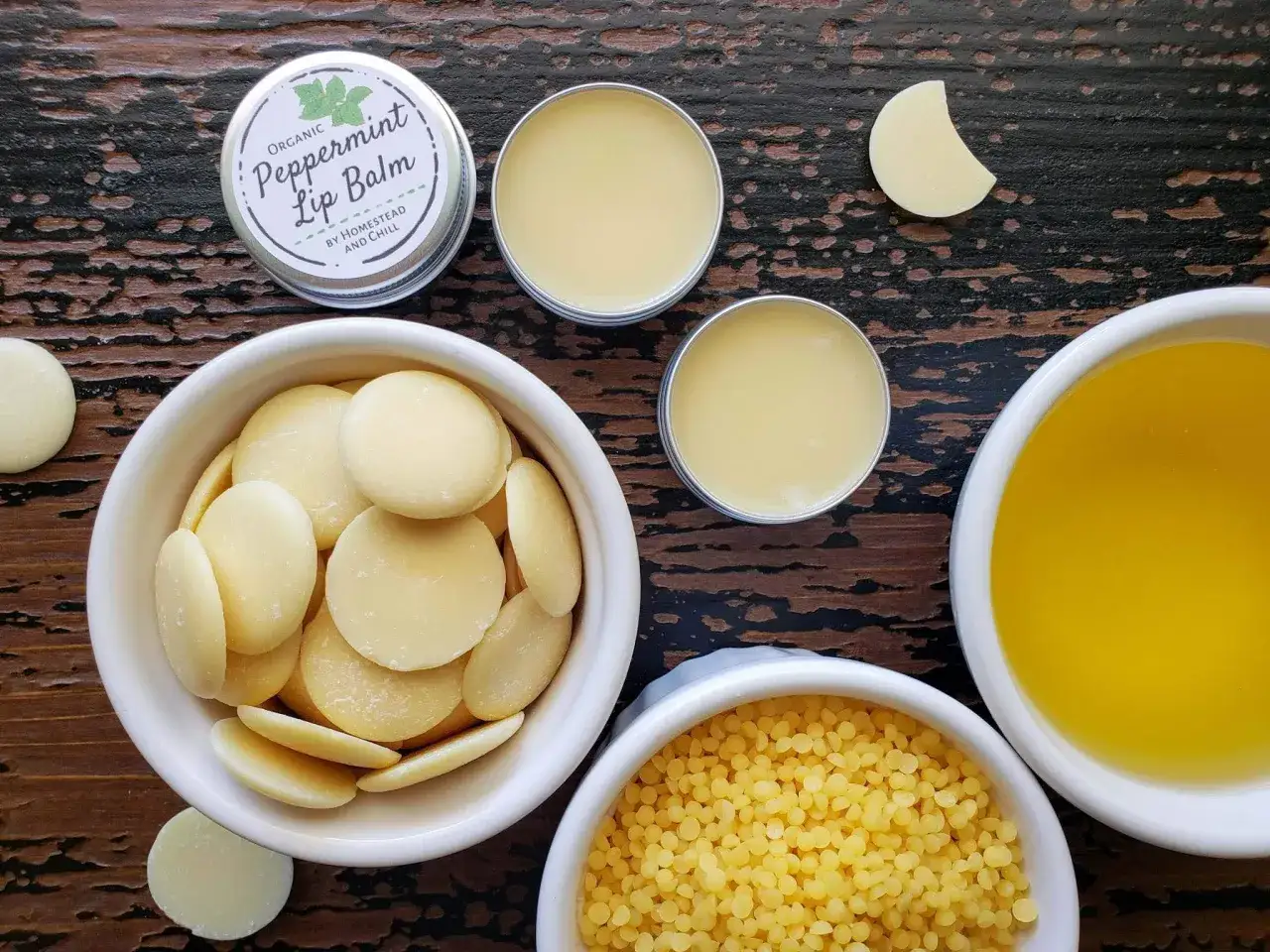 Zutaten für Lippenbalsam selber machen: Kakaobutter, Bienenwachs, Öl und eine Dose fertigen Lippenbalsam.