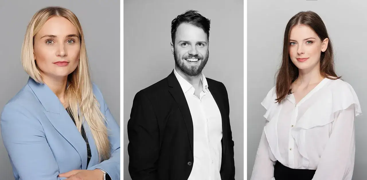 Profesjonalny opis fotografa: kobieta w niebieskiej marynarce, mężczyzna w czarnej marynarce i kobieta w białej bluzce.
