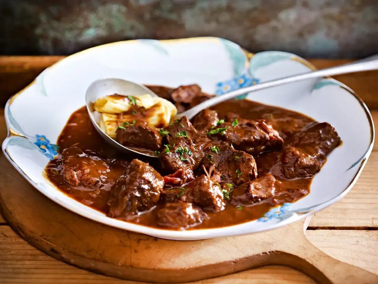 Klassisches deutsches Gulasch mit einem Klecks Schmand serviert