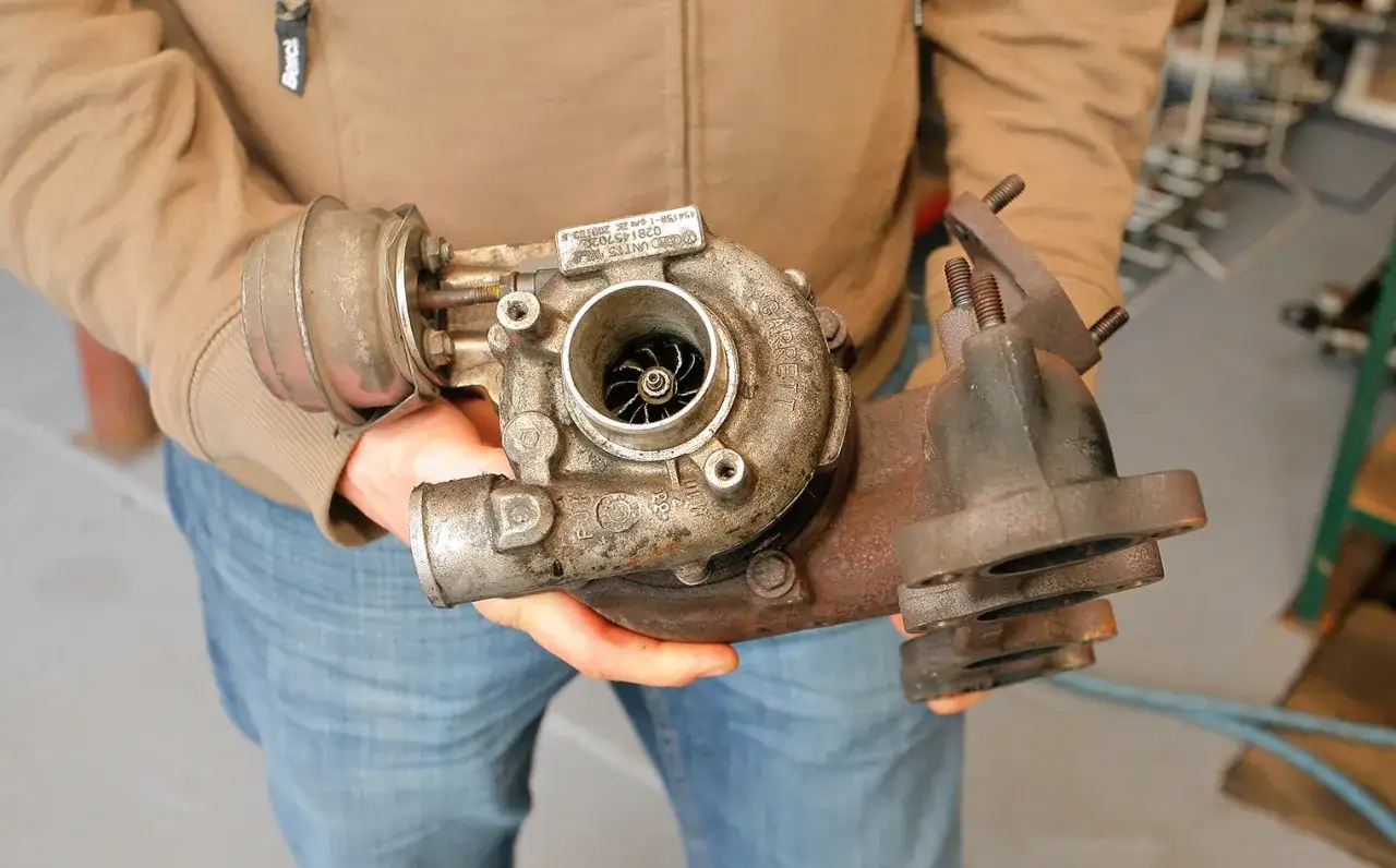 Osoba trzyma turbosprężarkę Garrett, element kluczowy dla mocy rozbieganego diesla.