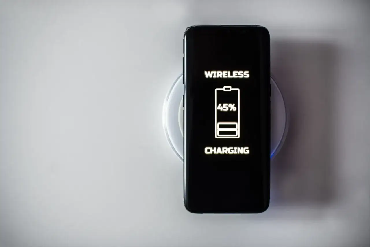 Smartfon na ładowarce indukcyjnej, ekran pokazuje 