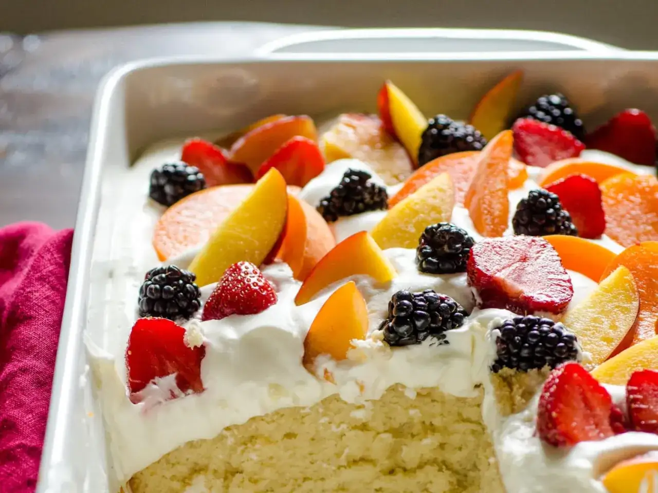 Ein saftiger Kuchen mit Sahne, Erdbeeren, Pfirsichen und Brombeeren. Perfekt für ein sommer dessert schnell und einfach.