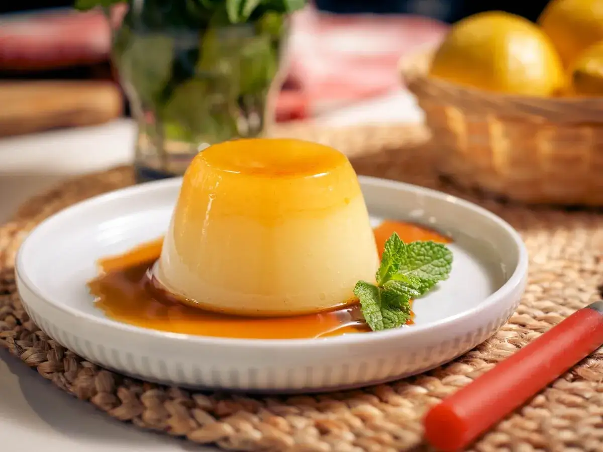 Delicioso flan de lim&oacute;n con caramelo l&iacute;quido, decorado con menta fresca. Un postre refrescante y dulce.