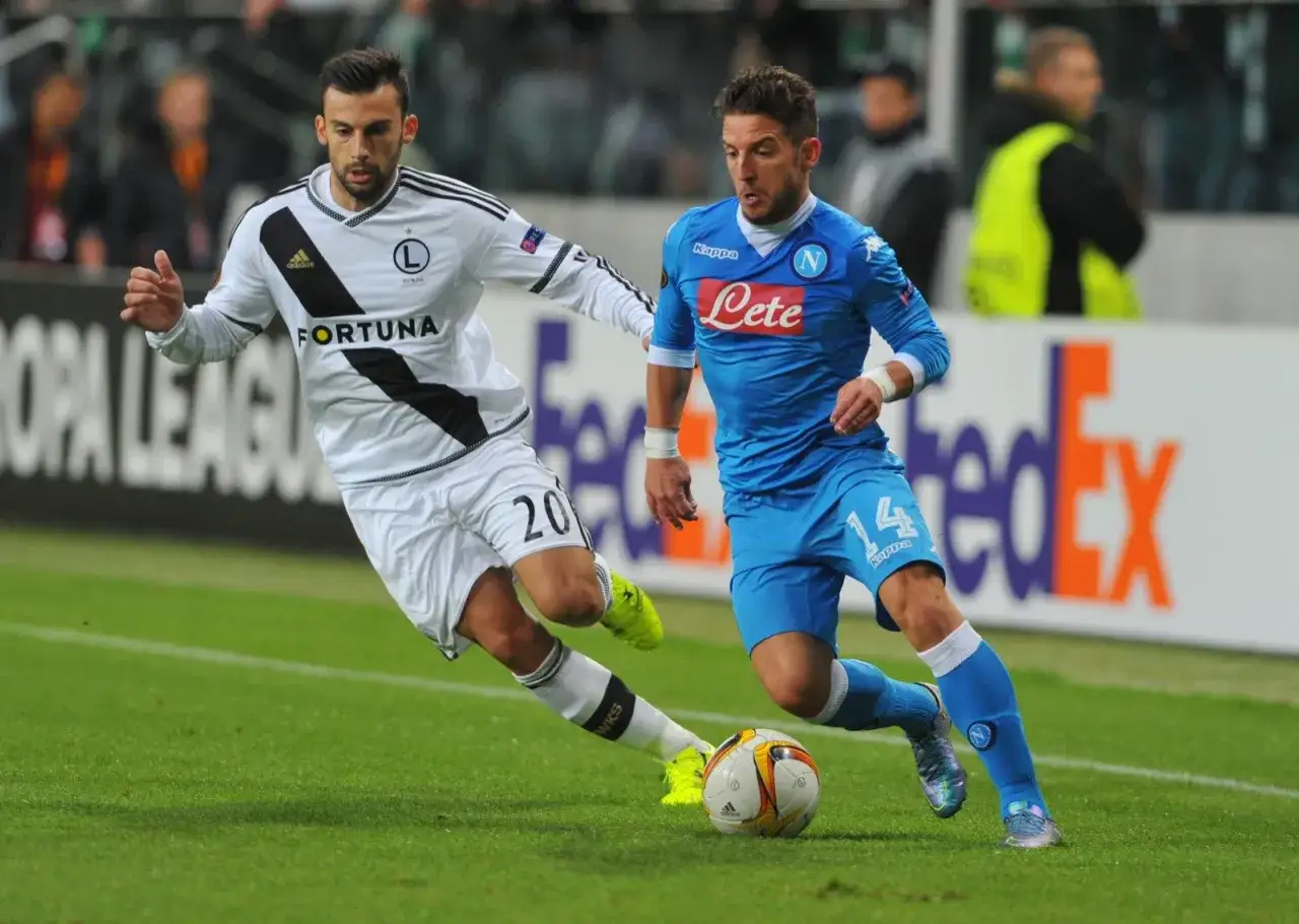 Piłkarz Napoli, Mertens, w akcji. Rywalizuje o piłkę z zawodnikiem w białej koszulce z numerem 20.