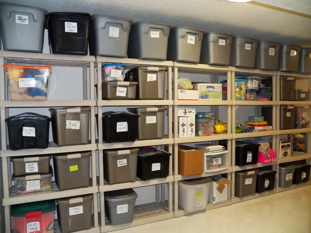 Estanterías llenas de cajas plásticas etiquetadas, un ejemplo de cómo organizar un trastero para tener todo a mano.