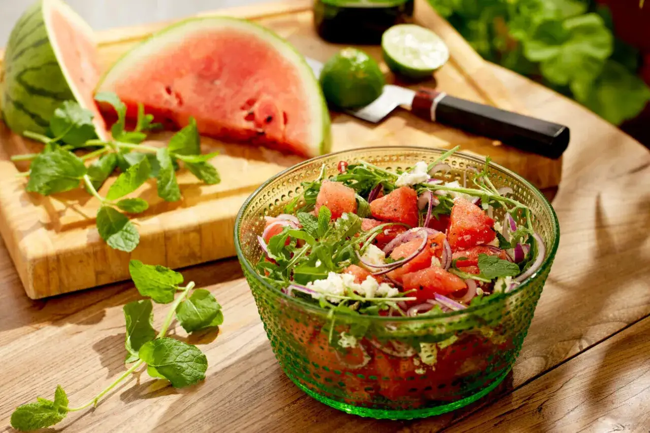 En uppfriskande melon och fetaostsallad med mynta och ruccola, redo att serveras.
