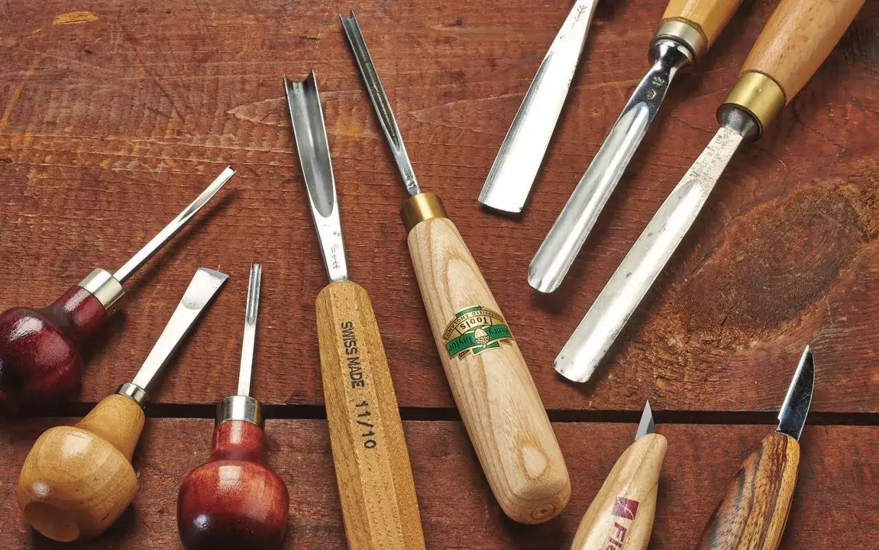 Ensemble d'outils manuels pour creuser le bois, incluant gouges et ciseaux de différentes tailles, prêts pour sculpter le bois.