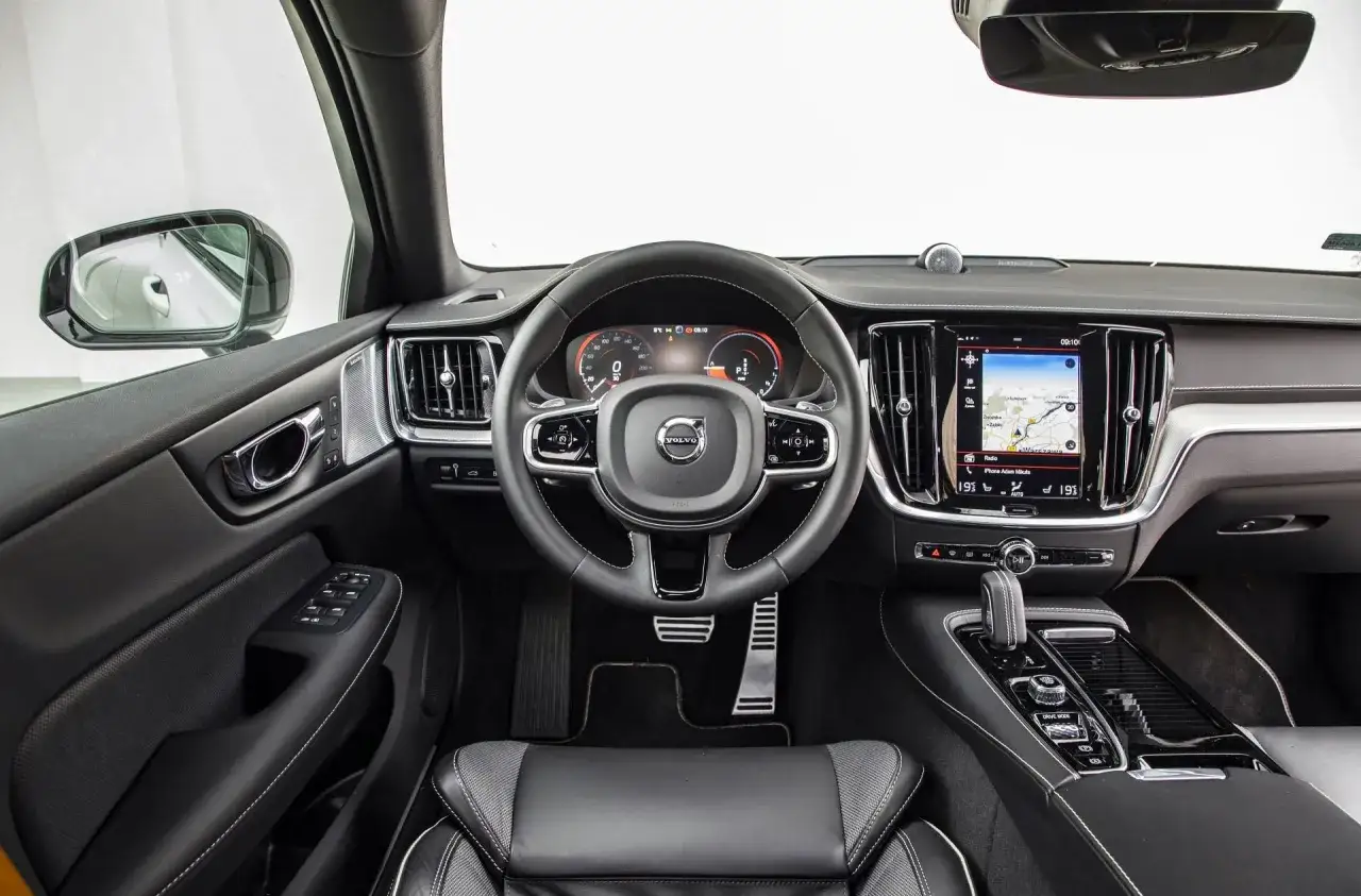 Wnętrze Volvo S60. Kierownica, ekran multimediów z nawigacją i panelem klimatyzacji. Jaki silnik? To pytanie nurtuje wielu kierowców.