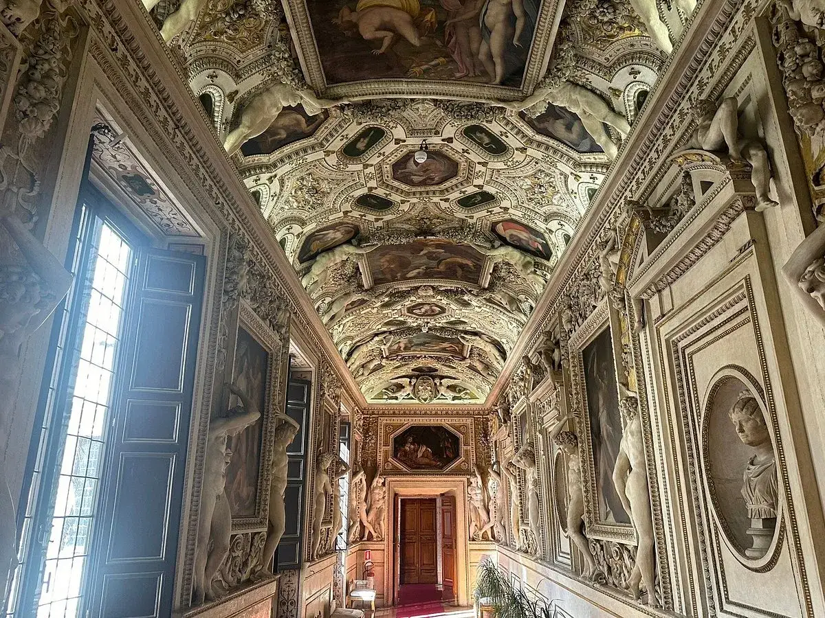 Corridoio affrescato con statue e stucchi nel **Palazzo Spada Roma**. Soffitto a cassettoni con dipinti e figure allegoriche.