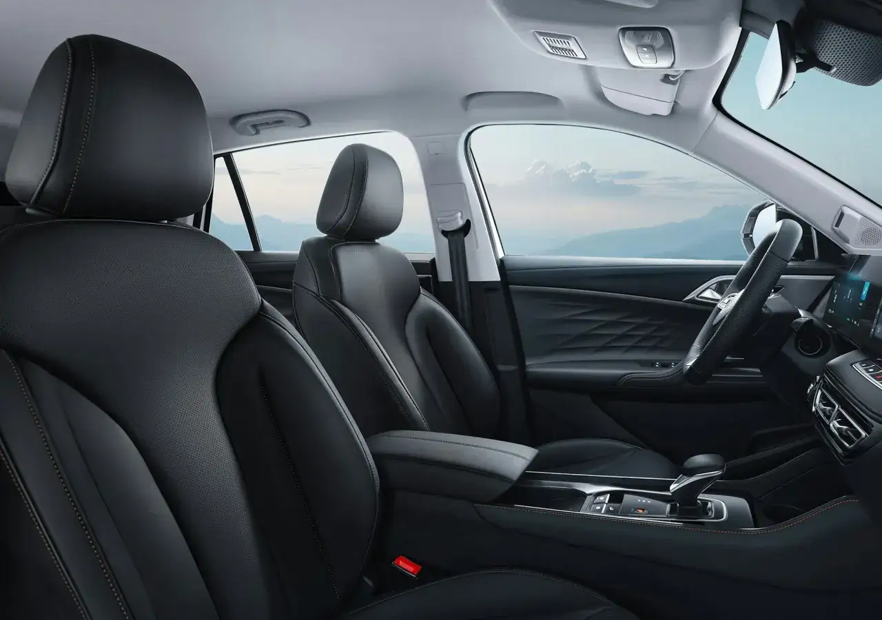 Interni lussuosi dell'MG HS Hybrid+, con sedili in pelle nera e cuciture a contrasto, pronti per un viaggio panoramico.