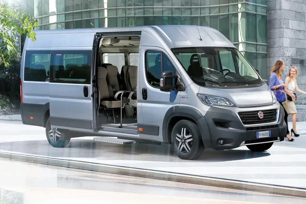 Srebrny bus z otwartymi drzwiami, w środku siedzenia. Zastanawiasz się, jakie prawo jazdy na busa?