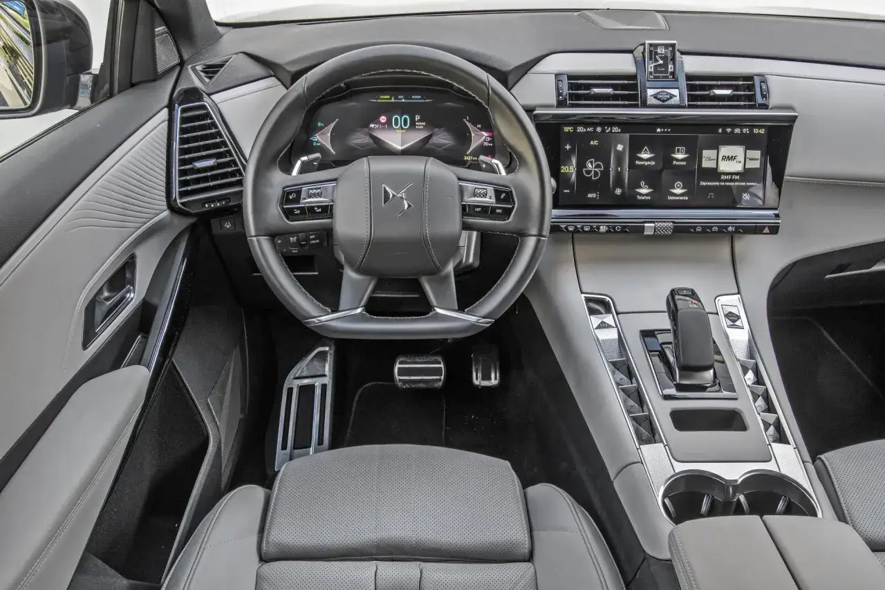 Wnętrze Citroen DS7 z cyfrowymi zegarami, ekranem dotykowym i elegancką kierownicą.